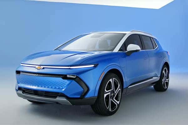 A blue SUV with a modern design is shown against a light blue background. The vehicle features sleek lines, a black grille, and silver accents around the windows and mirrors. The wheels have a distinctive pattern.