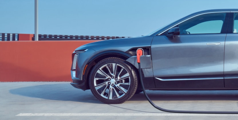 Electric vehicle charging in a modern garage, showcasing a plugged-in electric car with charging station mounted on the wall. The image highlights eco-friendly transportation and home charging convenience.