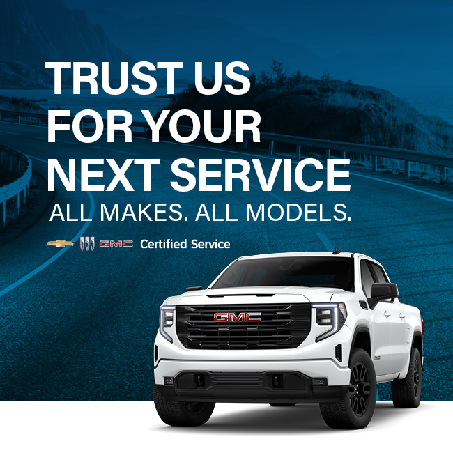 White GMC truck on a road with text promoting certified service for all makes and models.