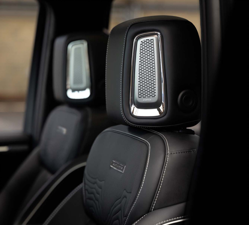 Luxury car interior with sleek black leather seats featuring premium speaker systems integrated into the headrests.