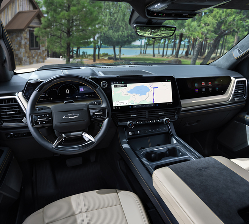 Modern vehicle interior with digital dashboard, touchscreen navigation, and beige leather seats, overlooking a scenic lake.