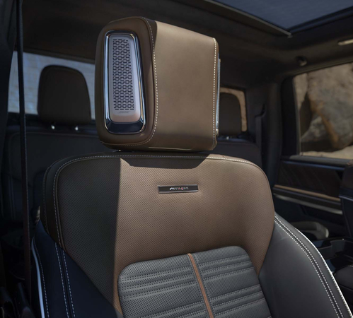Luxury SUV seat with brown leather and advanced headrest design. Premium interior details visible.
