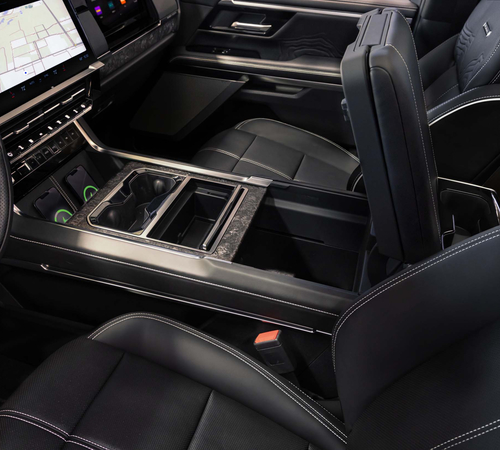 Luxury car interior with black leather seats, center console, cup holders, and a touchscreen display.