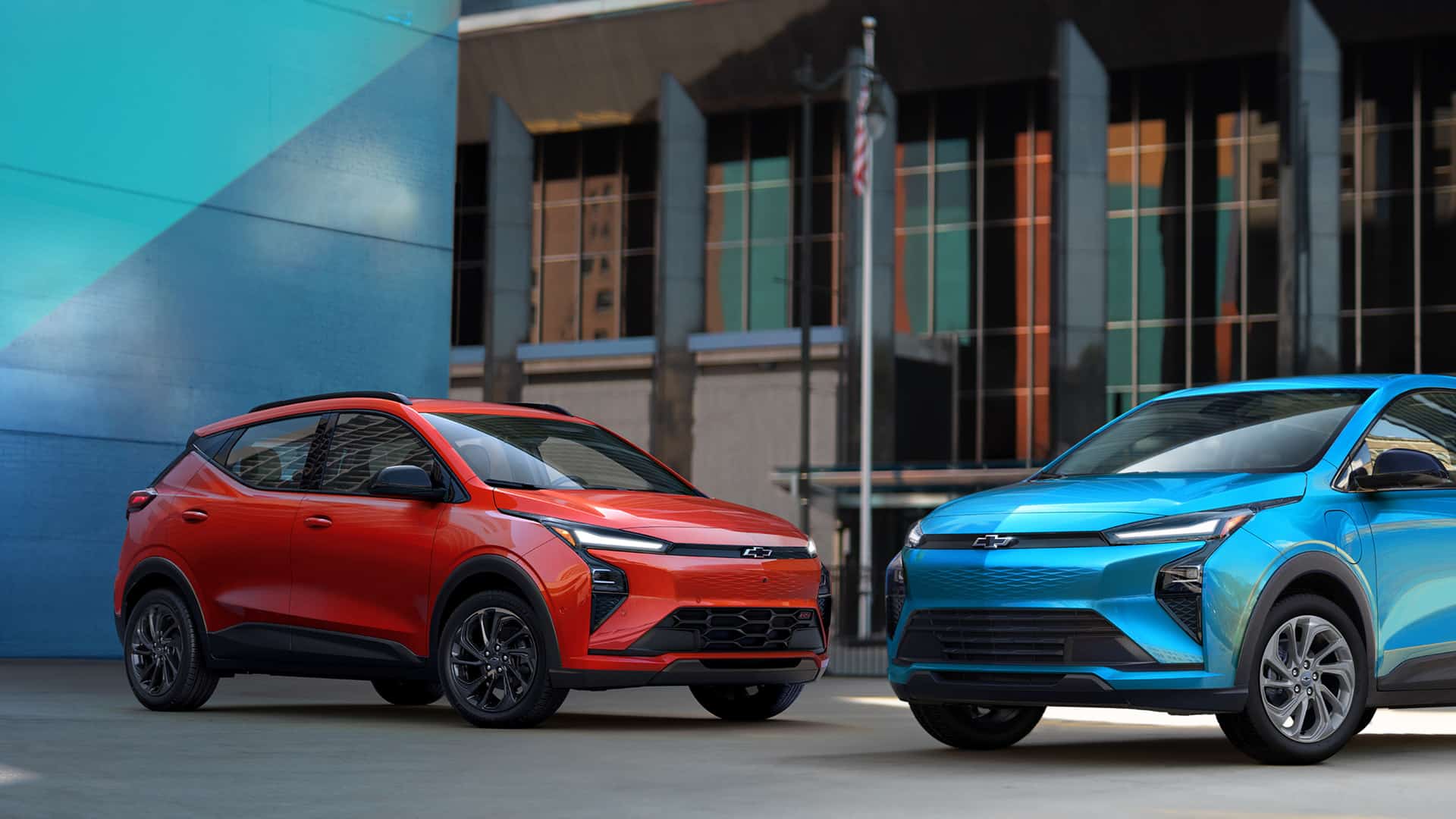 Red and blue Chevrolet SUVs parked in an urban setting, showcasing modern design.