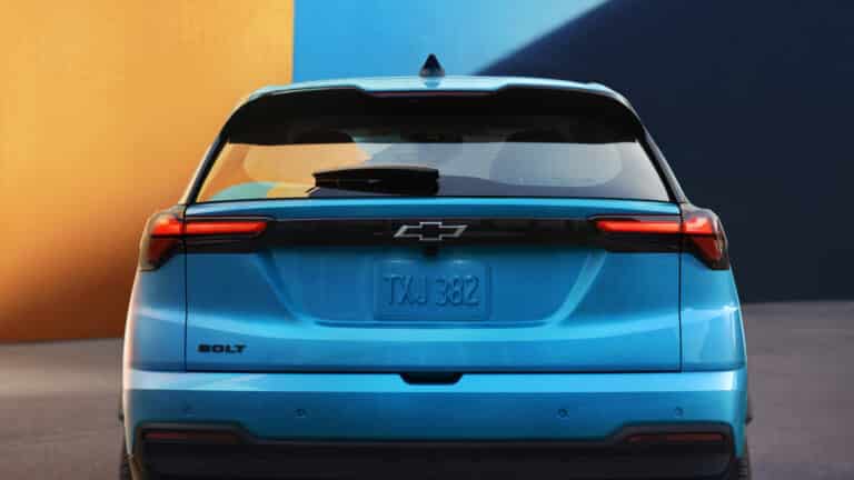 Bright blue electric car from behind against a colorful, modern backdrop.